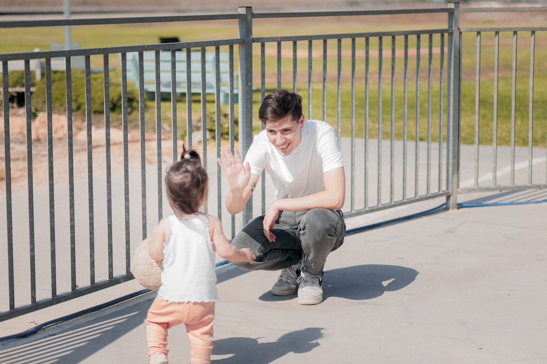 a man kneeling down next to a little girl